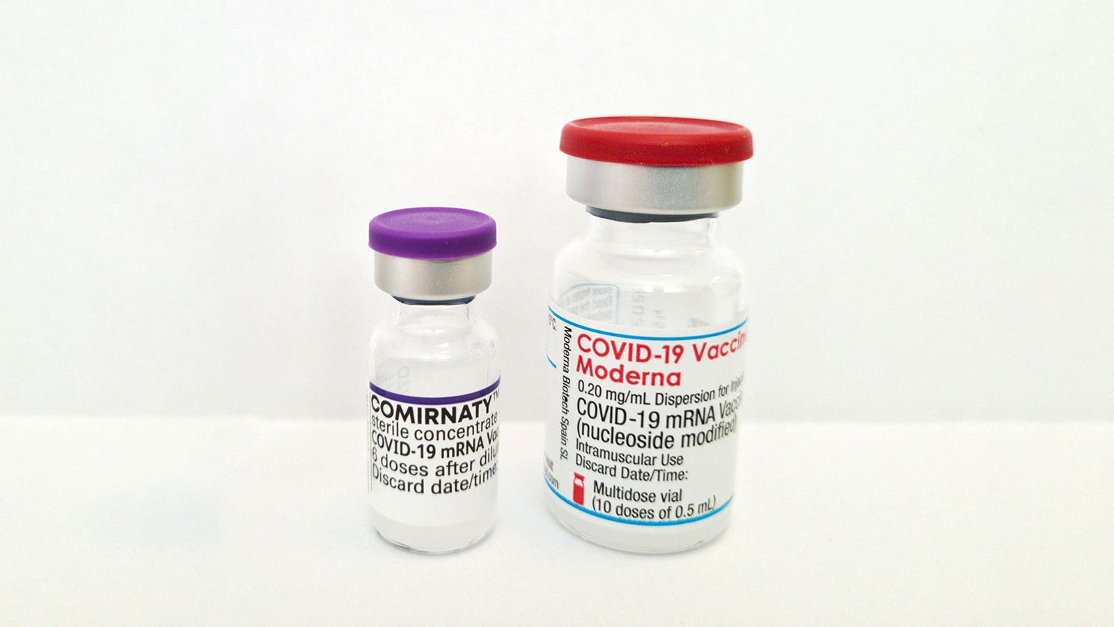 A photo of vials of Comirnaty and the Moderna COVID vaccines.