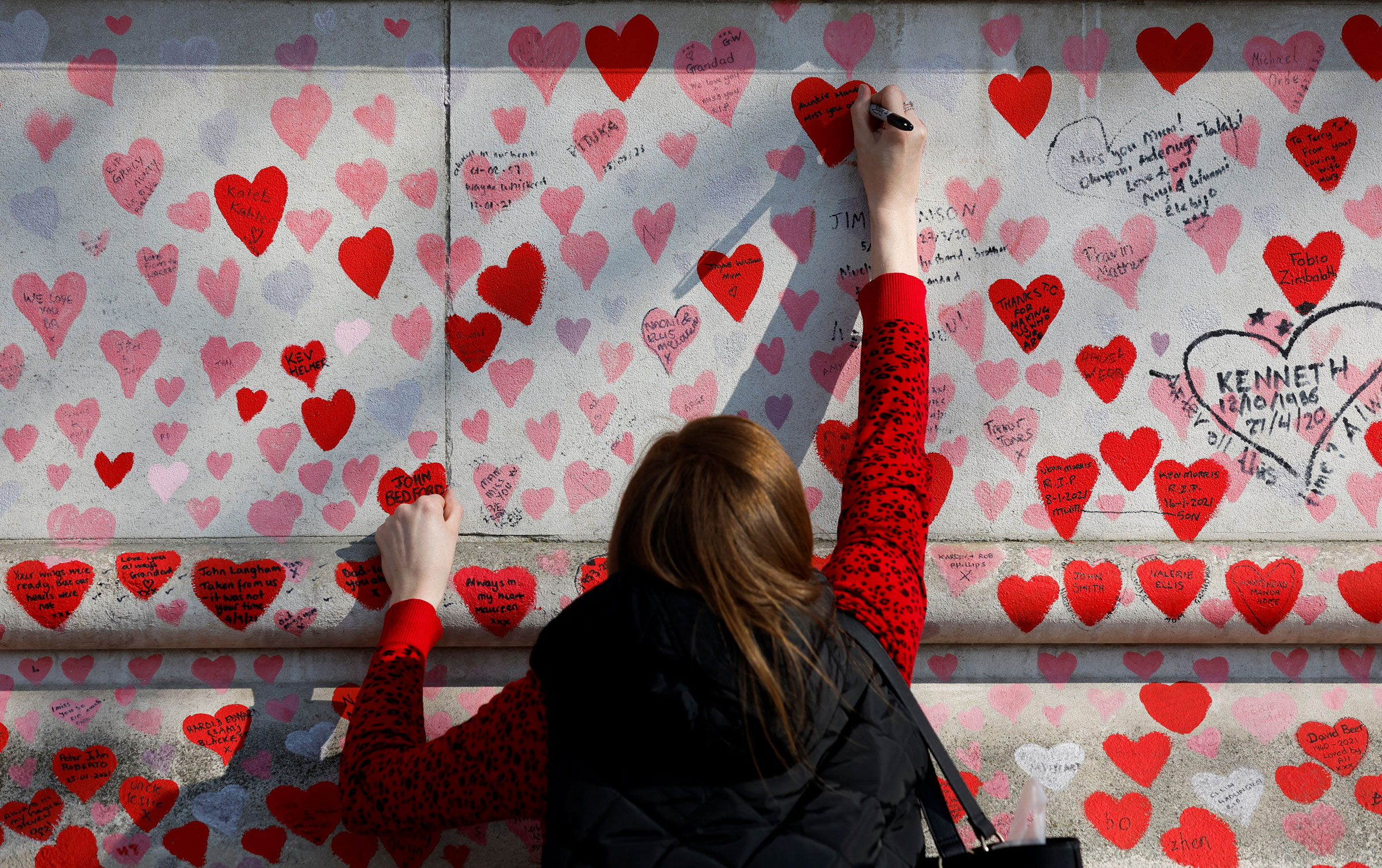 A person writes a message on The National Covid Memorial Wall, on national day of reflection to mark the two year anniversary of the UK going into national lockdown, in London A person writes a message on The National Covid Memorial Wall, on national day of reflection to mark the two year anniversary of the United Kingdom going into national lockdown, in London, on March 23, 2022.