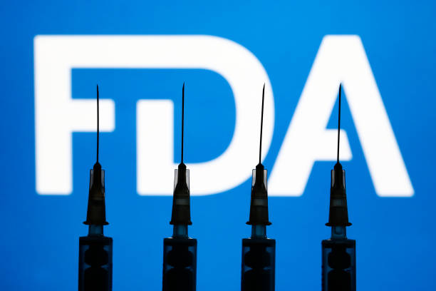 Medical syringes and FDA logo displayed in the background are seen in this illustration photo taken in Krakow, Poland on December 2, 2021. (Photo by Jakub Porzycki/NurPhoto via Getty Images)